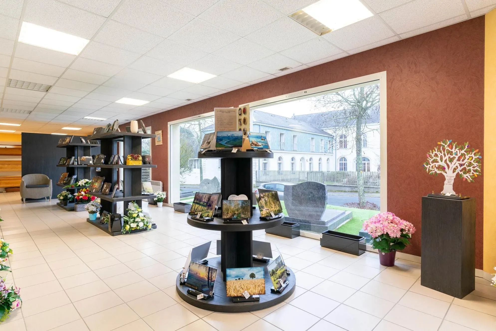 Boutique d'articles funéraires avec plaques, fleurs et urnes souvenir.
