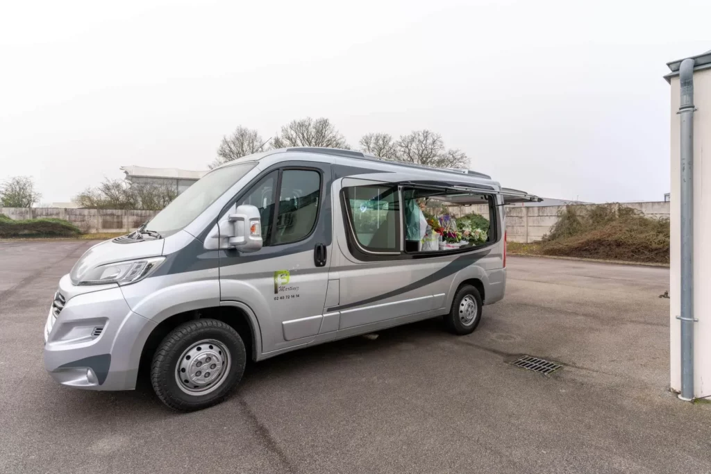 Camionnette funéraire grise Pompes Funèbres Martinez pour transport de corps.