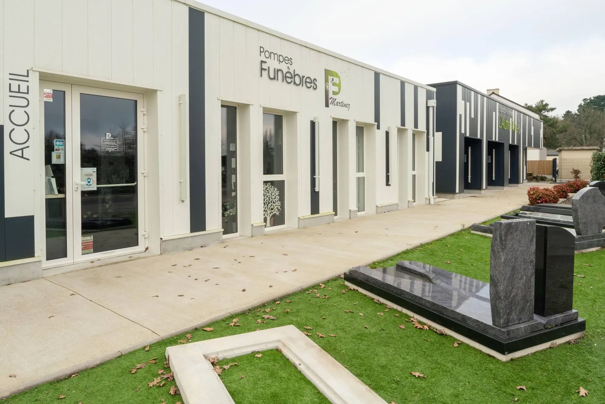 Façade extérieure de l'agence funéraire avec zone d'accueil et marbrerie.