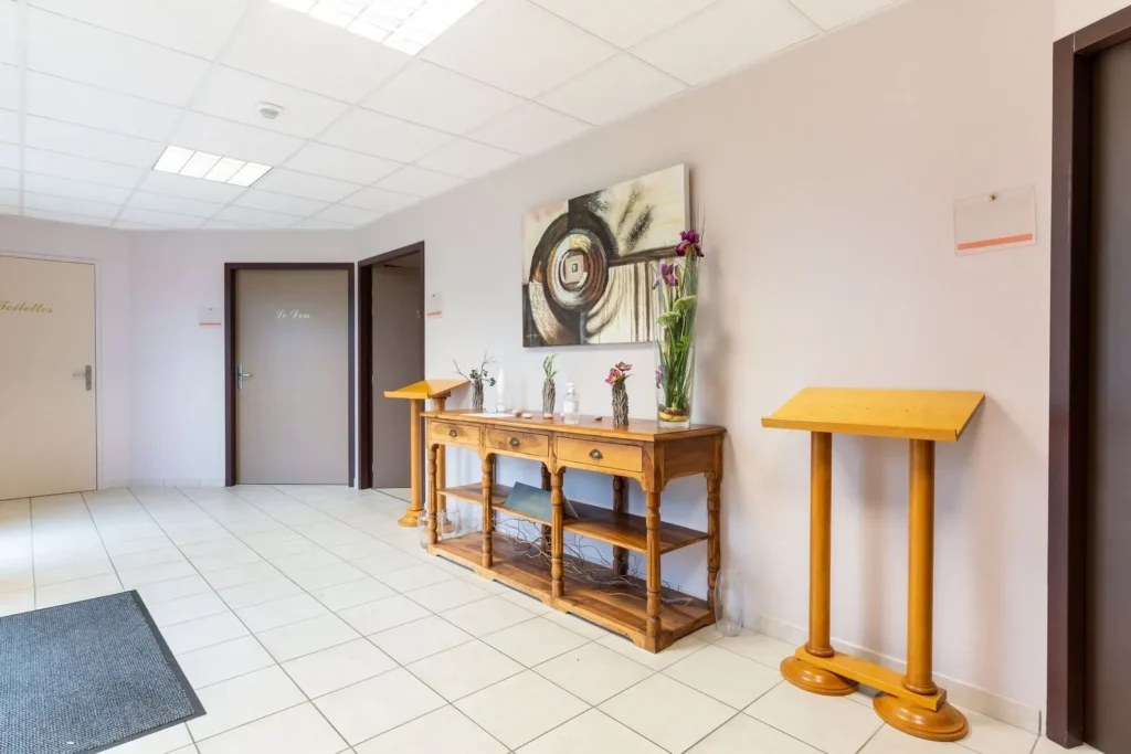 Hall d'accueil chaleureux avec pupitres de condoléances de la maison funéraire.