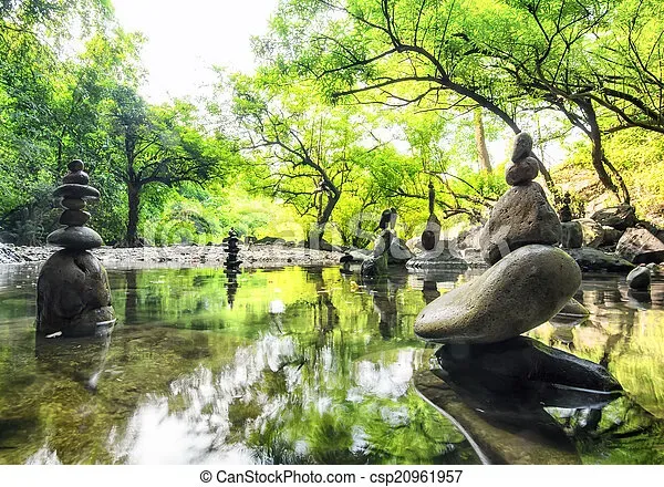 Cairns de pierres en équilibre dans une rivière au cœur d'une forêt zen.